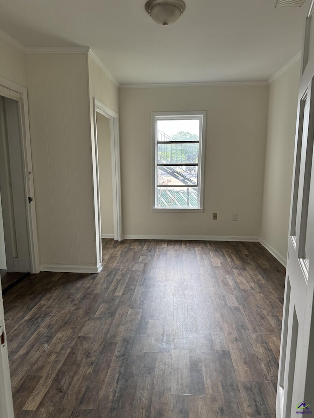 unfurnished bedroom with ornamental molding, dark wood-style floors, and baseboards