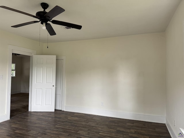 empty room featuring dark wood-style floors, baseboards, and a ceiling fan