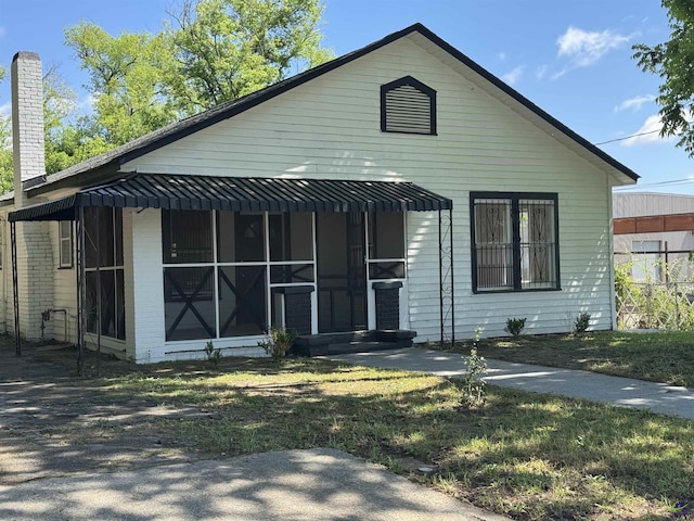 view of front of house featuring a sunroom and a chimney