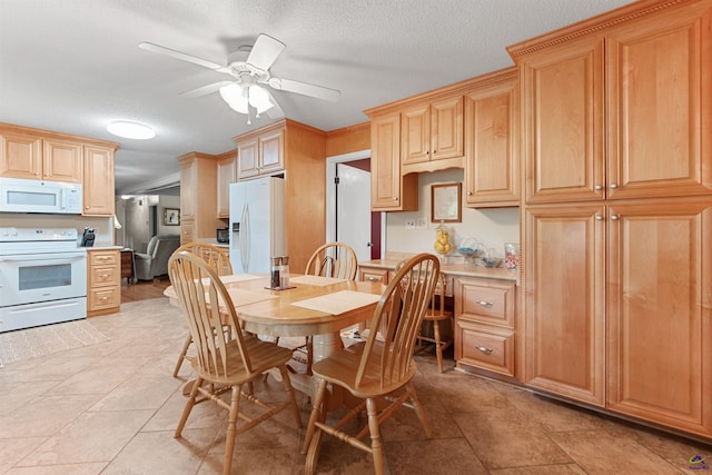 dining area featuring ceiling fan and a textured ceiling