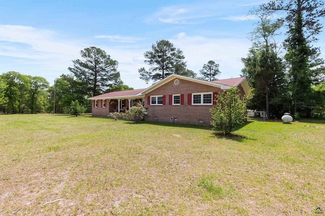 view of front facade with crawl space, brick siding, and a front yard