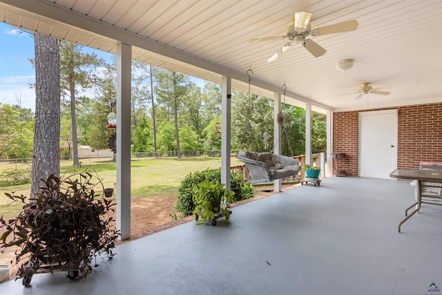 view of patio with ceiling fan and view of scattered trees