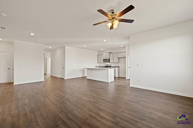unfurnished living room featuring recessed lighting, a ceiling fan, dark wood-style flooring, and baseboards