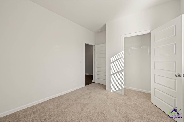 unfurnished bedroom featuring carpet flooring, baseboards, and a closet