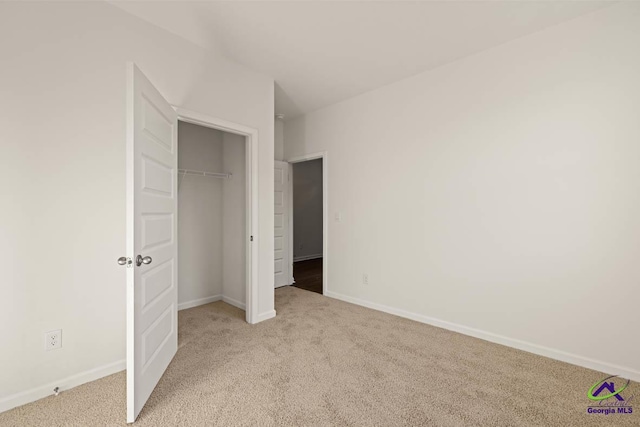 unfurnished bedroom featuring light carpet, baseboards, and a closet