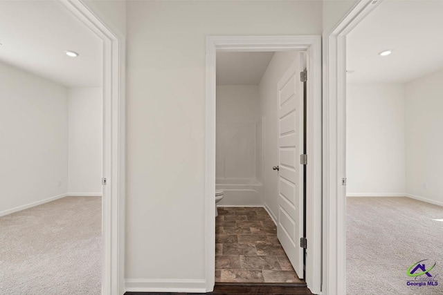 hallway featuring carpet floors, baseboards, and recessed lighting