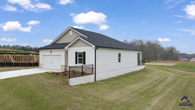view of side of home with concrete driveway and an attached garage