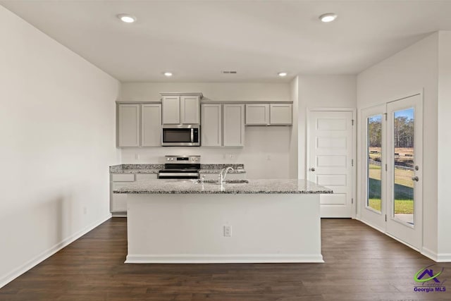 kitchen with appliances with stainless steel finishes, gray cabinets, an island with sink, healthy amount of natural light, and recessed lighting