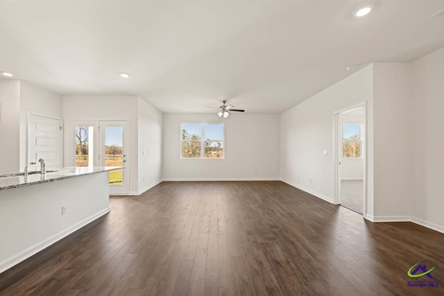 unfurnished living room with a ceiling fan, dark wood-style floors, a sink, baseboards, and recessed lighting