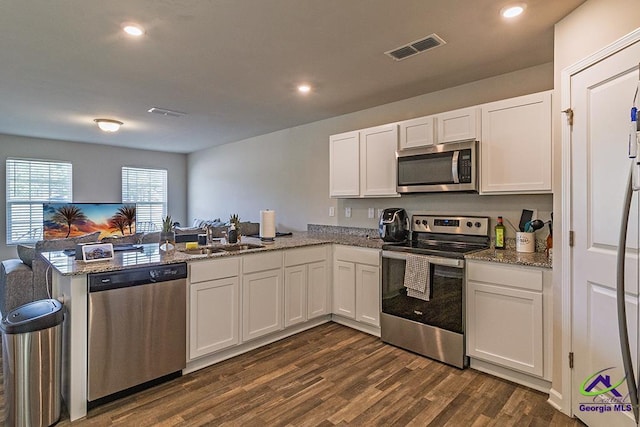 1707 Hannah Ct, Macon, GA 31217 - kitchen with appliances with stainless steel finishes, a sink, a peninsula, white cabinets, and dark wood finished floors