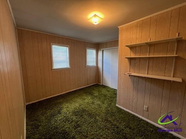 726 Mcarthur Blvd, Warner Robins, GA 31093 - empty room with dark colored carpet and wood walls