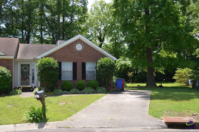 view of front of home featuring brick siding and a front lawn