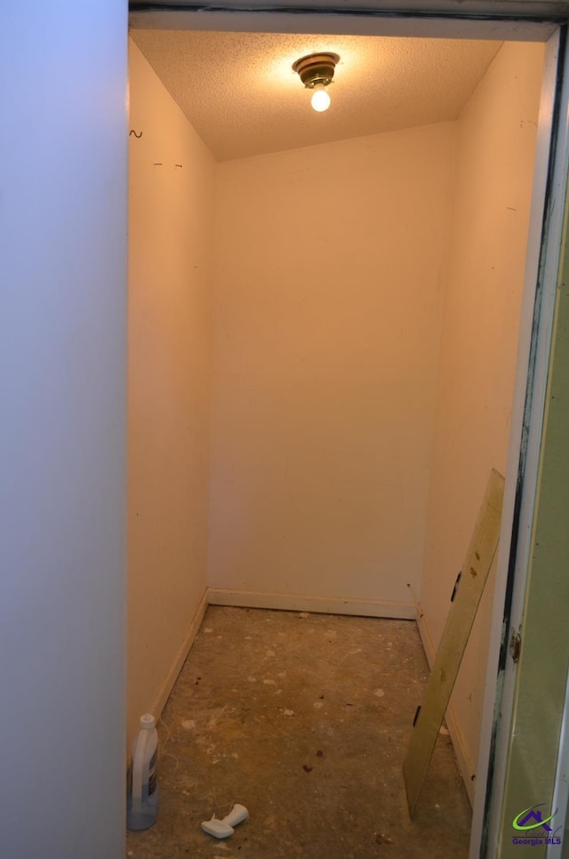 hallway with baseboards and a textured ceiling