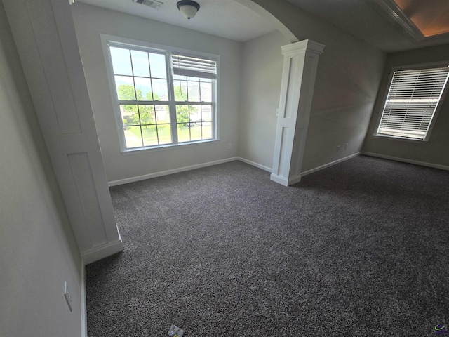 212 Raleigh Dr, Warner Robins, GA 31088 - spare room featuring arched walkways, baseboards, and dark carpet