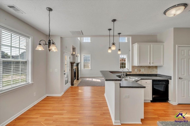 212 Raleigh Dr, Warner Robins, GA 31088 - kitchen featuring a sink, a peninsula, dark countertops, white cabinetry, and a textured ceiling