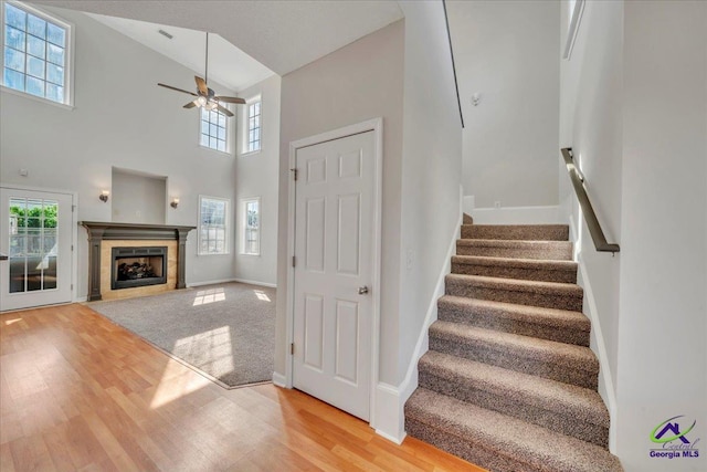 212 Raleigh Dr, Warner Robins, GA 31088 - stairs featuring wood finished floors, ceiling fan, high vaulted ceiling, a fireplace, and baseboards