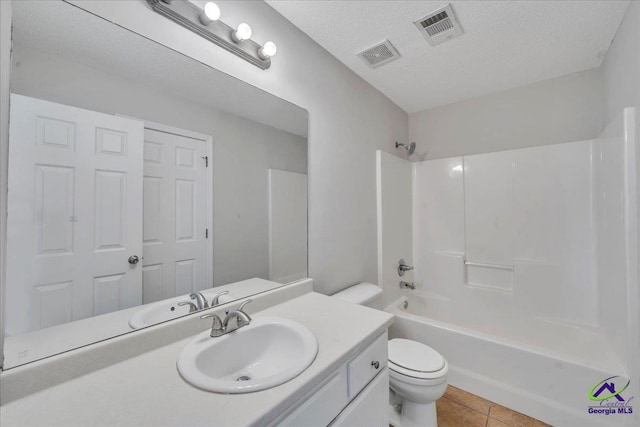 212 Raleigh Dr, Warner Robins, GA 31088 - bathroom featuring toilet, vanity, tile patterned floors, washtub / shower combination, and a textured ceiling
