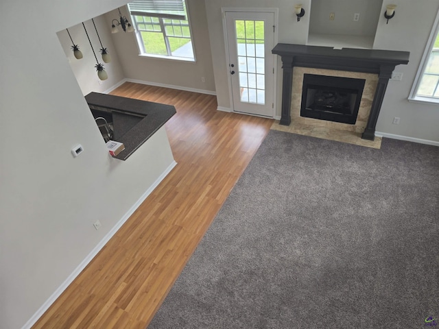 212 Raleigh Dr, Warner Robins, GA 31088 - unfurnished living room with a tiled fireplace, wood finished floors, and baseboards