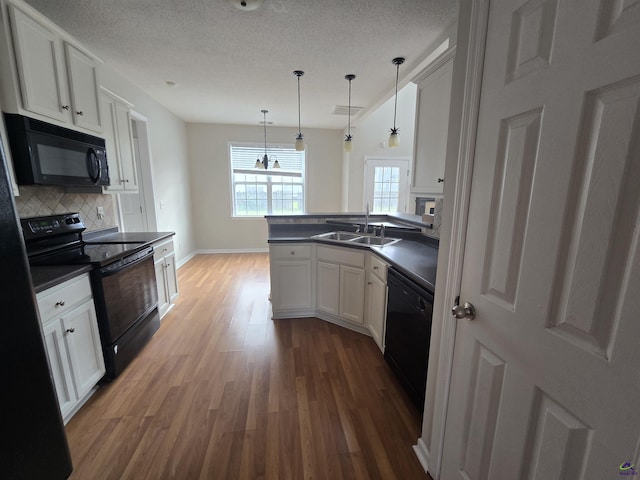 212 Raleigh Dr, Warner Robins, GA 31088 - kitchen featuring black appliances, a sink, dark countertops, wood finished floors, and backsplash