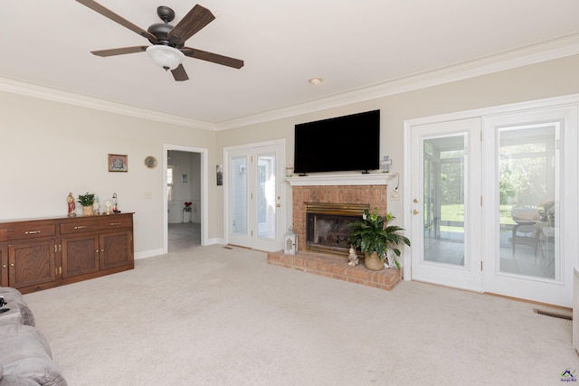 living area with crown molding, light carpet, a brick fireplace, baseboards, and a ceiling fan
