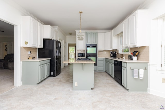 kitchen featuring black appliances, plenty of natural light, ornamental molding, a kitchen island, and backsplash