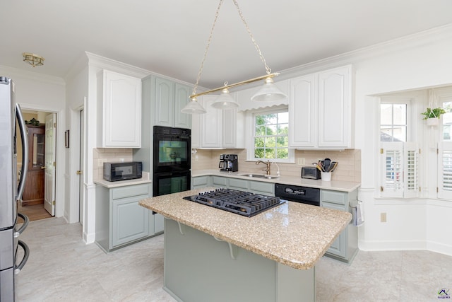 kitchen featuring black appliances, a sink, a center island, ornamental molding, and backsplash