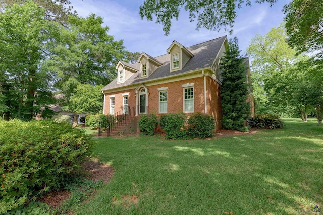 view of side of property featuring brick siding and a lawn