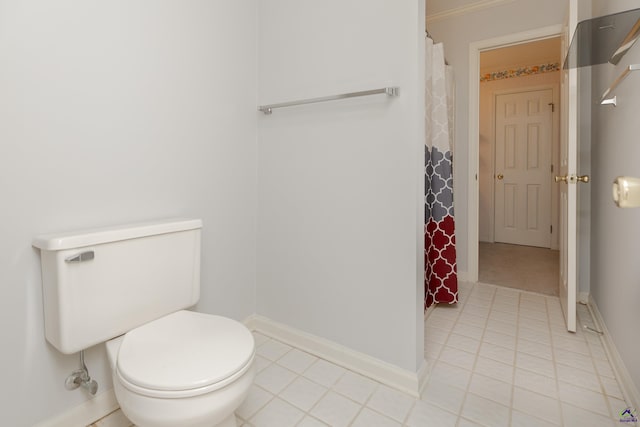 full bathroom featuring tile patterned flooring, toilet, baseboards, curtained shower, and crown molding