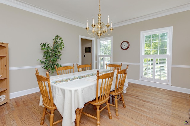 dining area with a chandelier, ornamental molding, light wood-type flooring, and baseboards