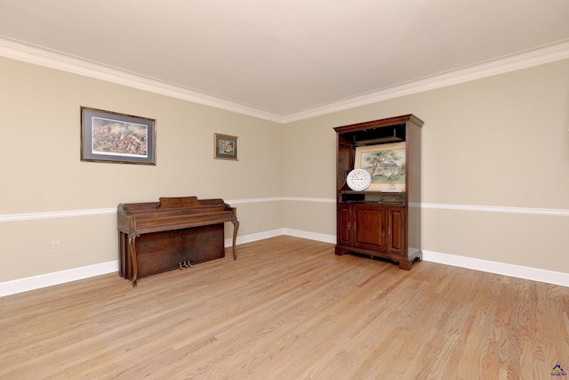 sitting room featuring ornamental molding, light wood-style flooring, and baseboards