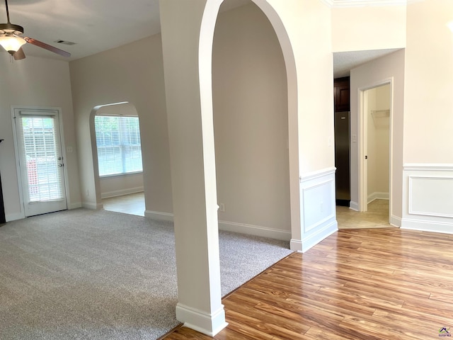 1187 Camden Ct, Warner Robins, GA 31088 - unfurnished living room with arched walkways, ceiling fan, light wood finished floors, and baseboards