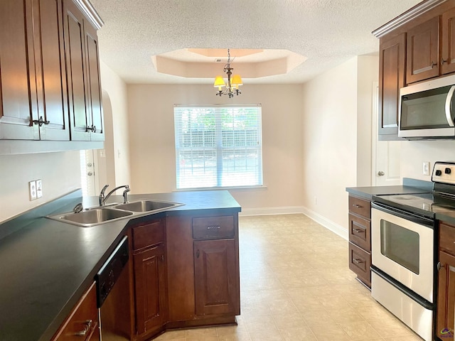 1187 Camden Ct, Warner Robins, GA 31088 - kitchen featuring stainless steel appliances, a sink, dark countertops, a textured ceiling, and a peninsula