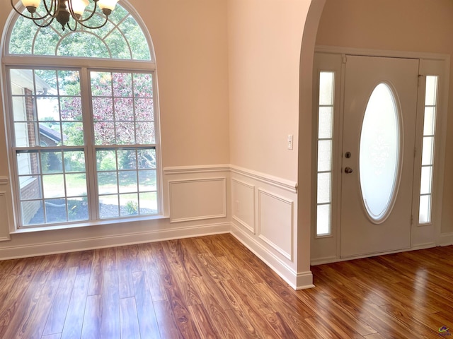 1187 Camden Ct, Warner Robins, GA 31088 - entryway featuring a chandelier, wood finished floors, arched walkways, wainscoting, and a decorative wall