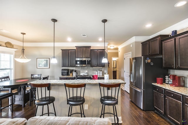 kitchen featuring appliances with stainless steel finishes, dark brown cabinets, a breakfast bar, ornamental molding, and dark wood-style floors