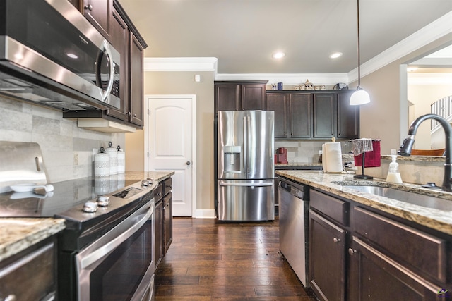 kitchen with appliances with stainless steel finishes, a sink, crown molding, dark brown cabinetry, and tasteful backsplash