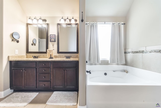 bathroom featuring a bath, double vanity, and tile patterned floors