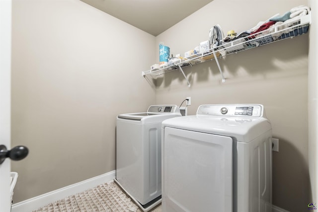 washroom with washer and clothes dryer and baseboards
