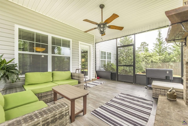 sunroom with outdoor lounge area, a ceiling fan, and a jacuzzi