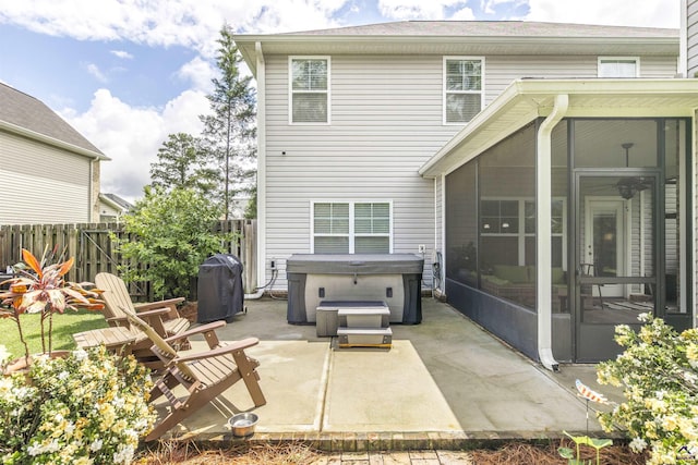 back of house with a sunroom, a hot tub, a patio, and fence