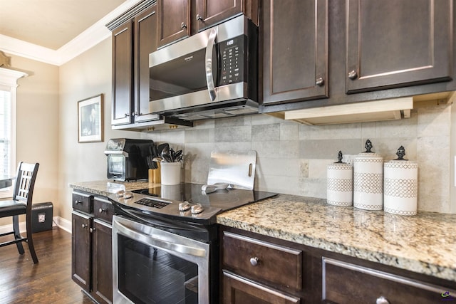 kitchen with stainless steel appliances, crown molding, dark brown cabinetry, decorative backsplash, and dark wood finished floors