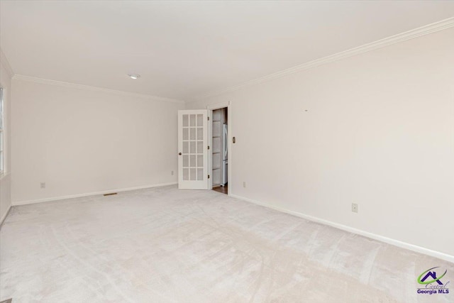 unfurnished room with crown molding, baseboards, and light colored carpet