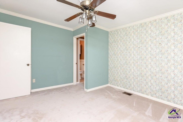 empty room featuring carpet flooring, ceiling fan, crown molding, and baseboards