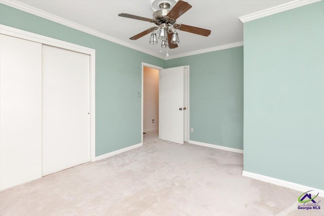 unfurnished bedroom featuring ornamental molding, carpet flooring, a closet, baseboards, and a ceiling fan