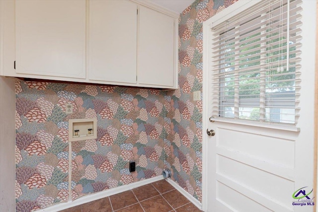 laundry area featuring washer hookup, dark tile patterned flooring, cabinet space, wallpapered walls, and baseboards