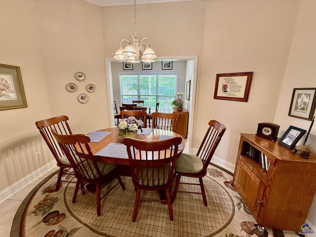 dining room with a chandelier, baseboards, crown molding, and a high ceiling