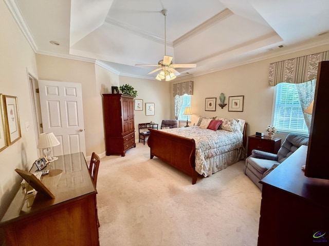 bedroom with a tray ceiling, light carpet, crown molding, and ceiling fan