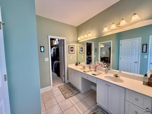 full bath featuring tile patterned flooring, double vanity, ceiling fan, a spacious closet, and baseboards