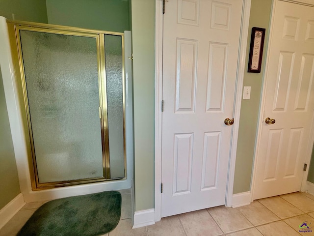 full bath featuring baseboards, a stall shower, and tile patterned flooring