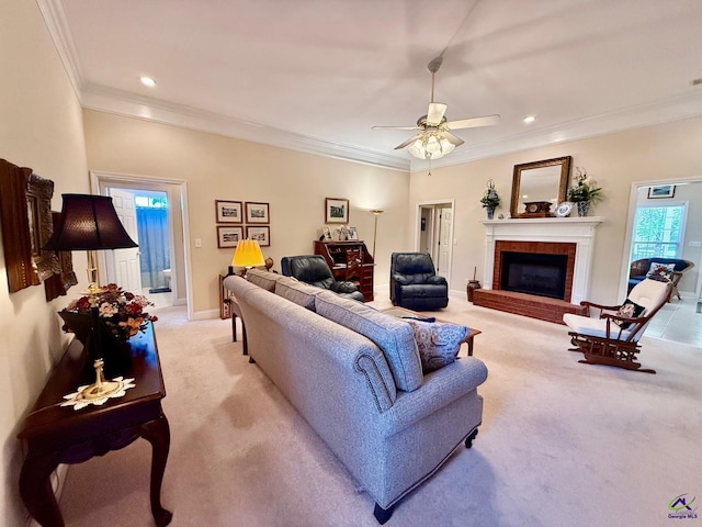 living room featuring light colored carpet, crown molding, a fireplace, a ceiling fan, and recessed lighting