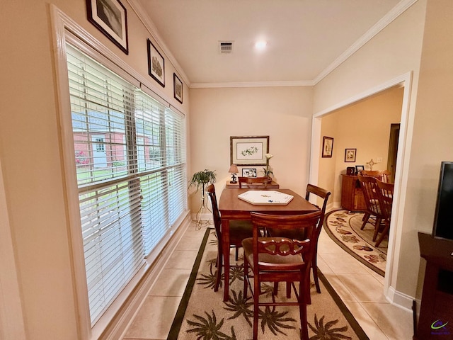 dining area with light tile patterned floors, ornamental molding, and baseboards